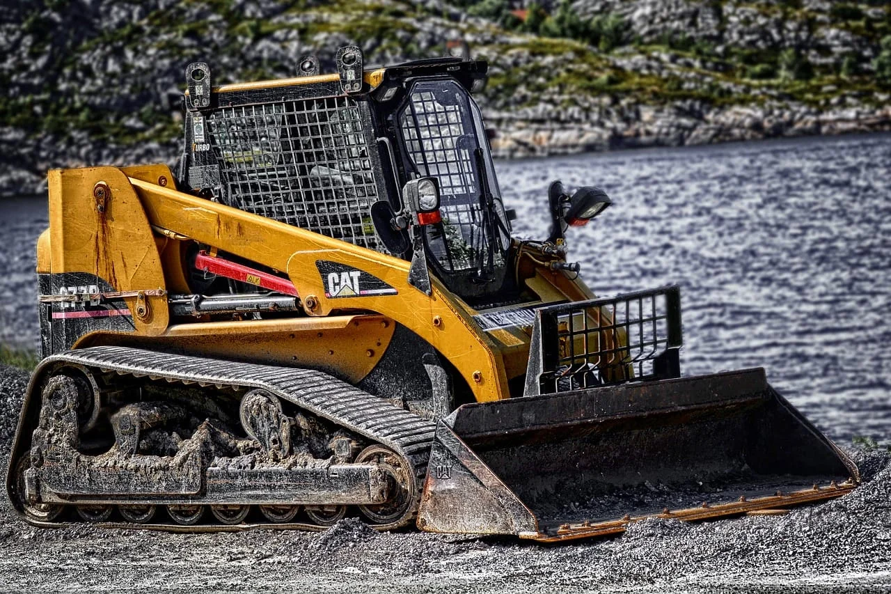 Tracked loader and bucket on a gravel work site