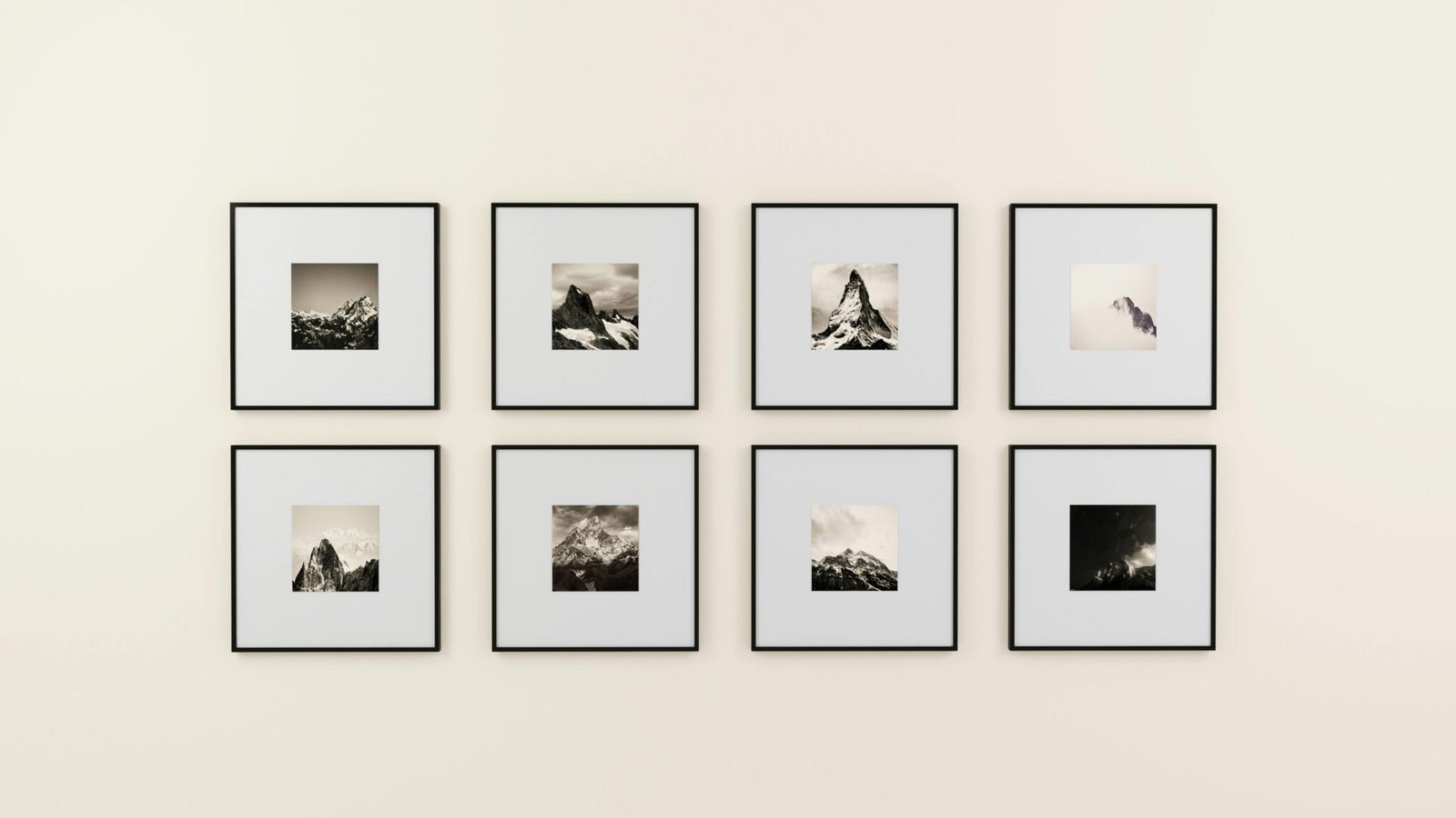 A minimalist display of framed mountain photography on a plain wall.